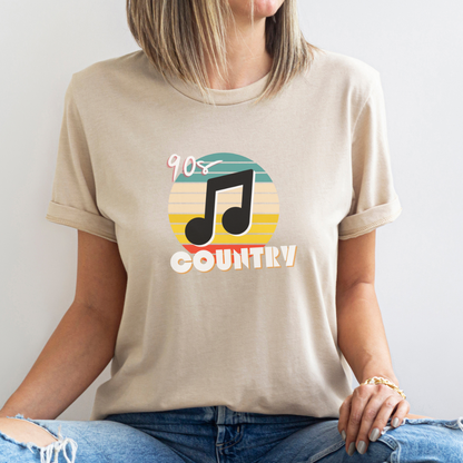 Woman wearing a cream colored tshirt that says "90s country" with a music note and colorful background