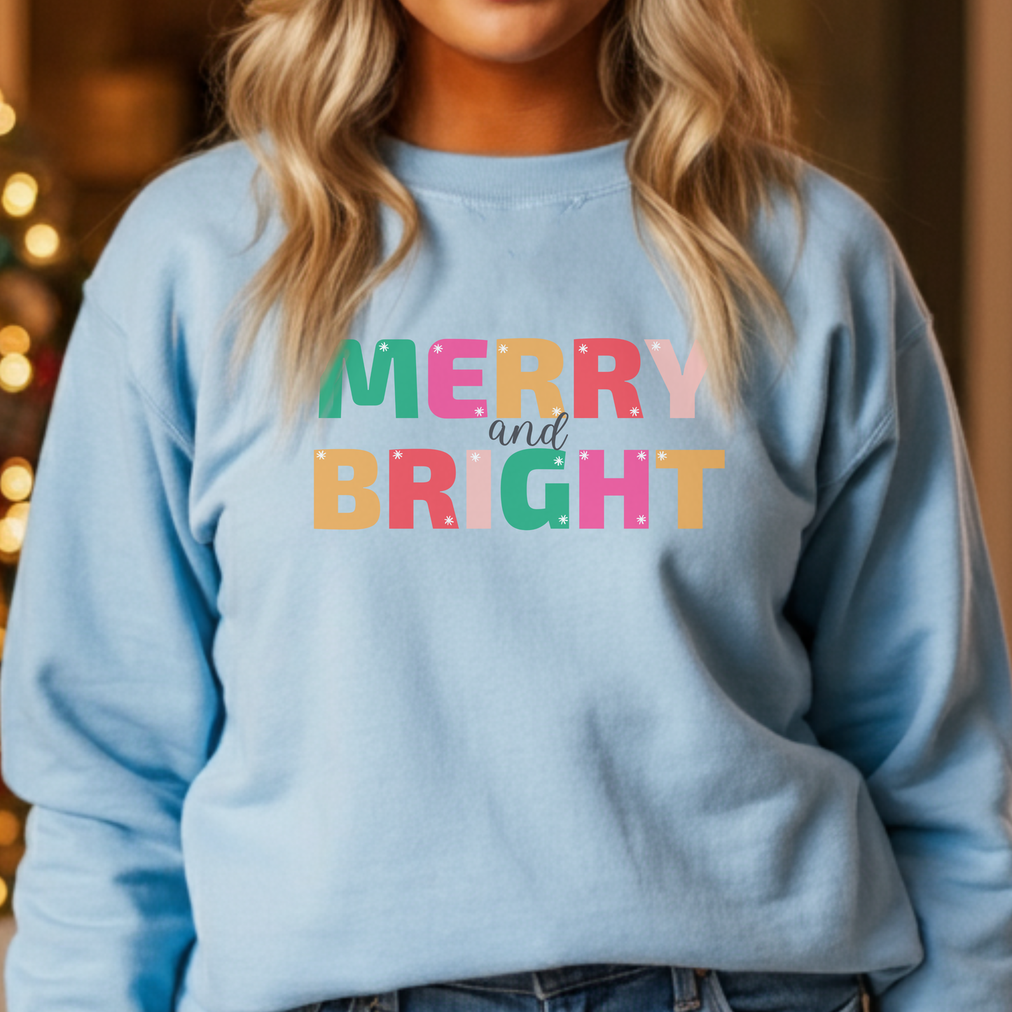 Woman wearing Merry and Bright Christmas sweatshirt in light blue.